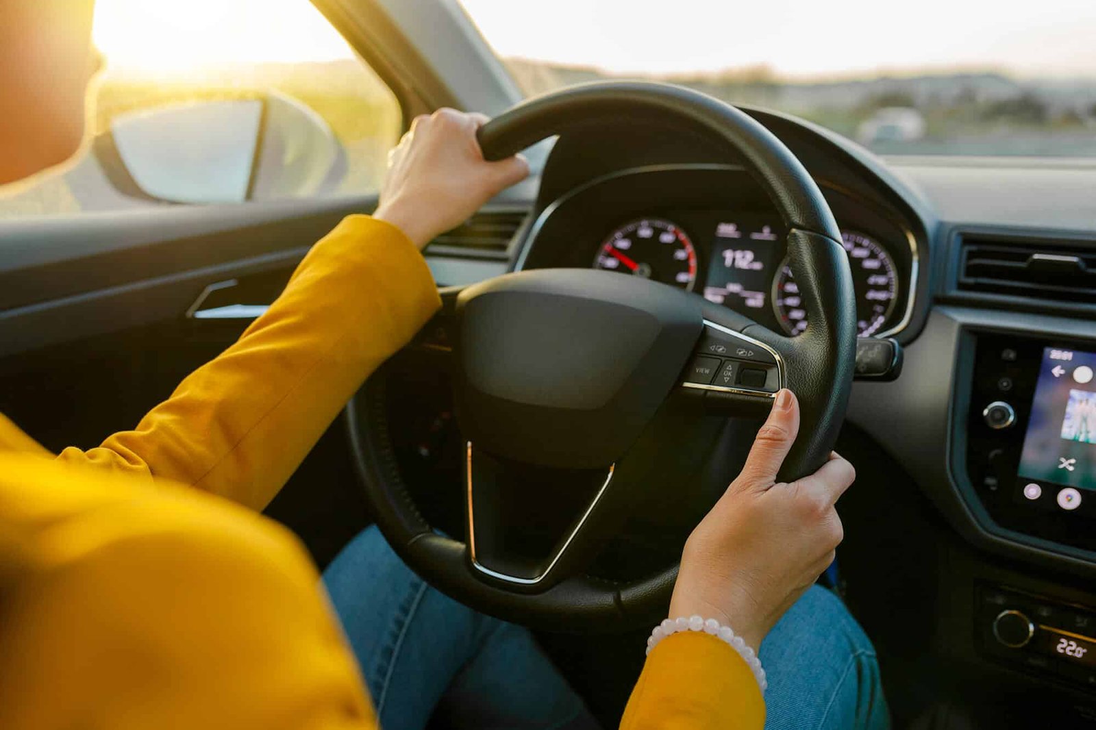 close-up-female-hands-in-yellow-suit-driving-car-o-2022-04-13-21-12-05-utc.jpg